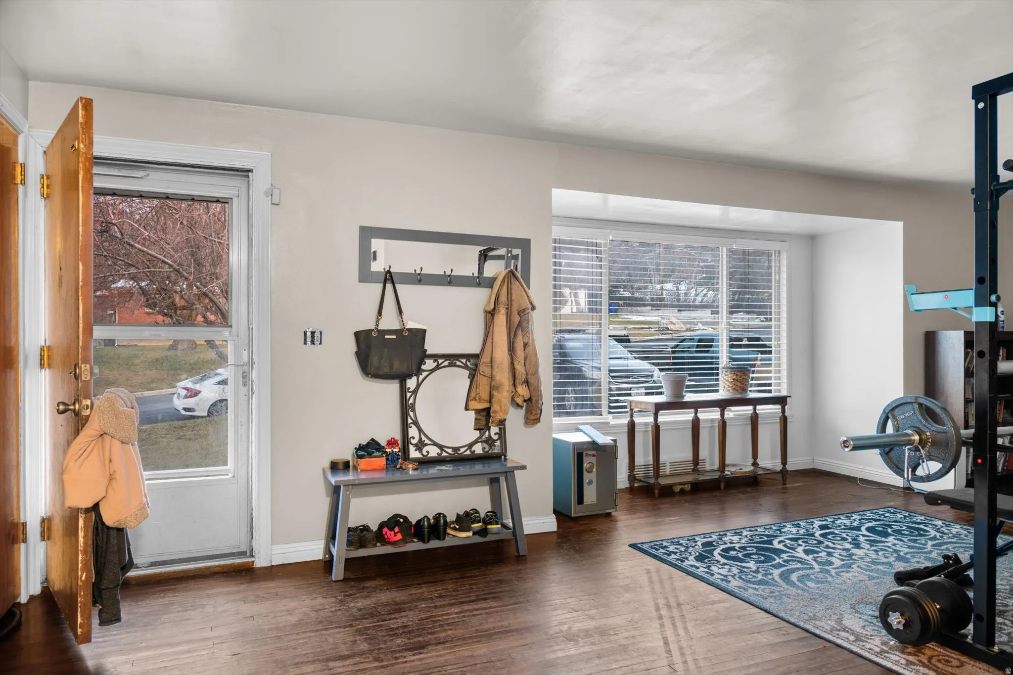 Entryway featuring wood-finish flooring, a full-lite storm door, and a built-in window bench