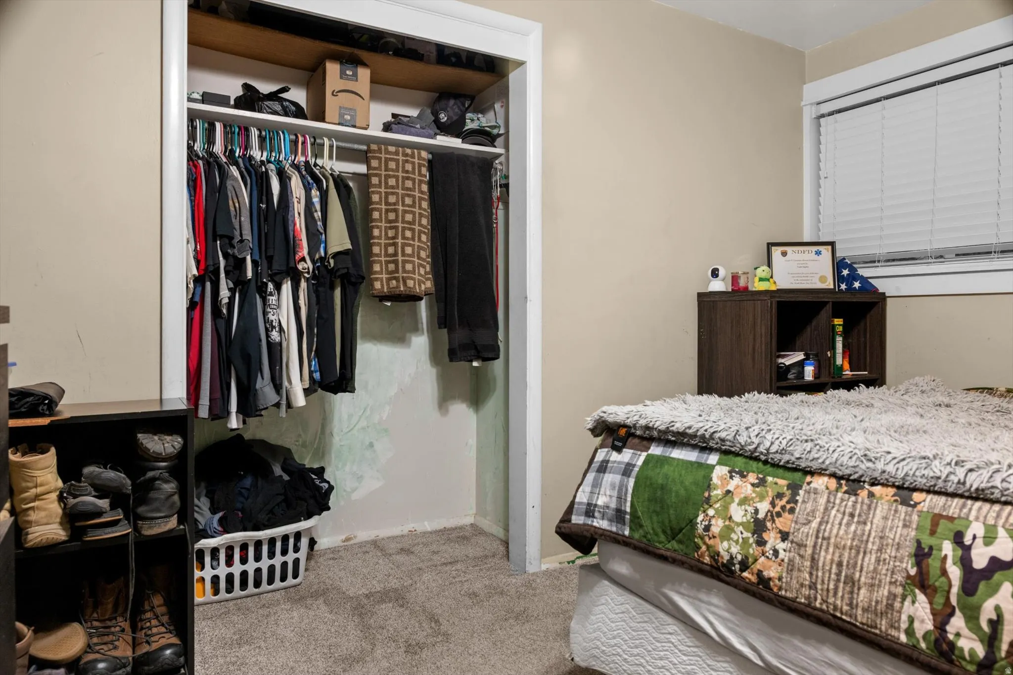 Bedroom featuring neutral painted walls, carpeted flooring, and a window with horizontal blinds