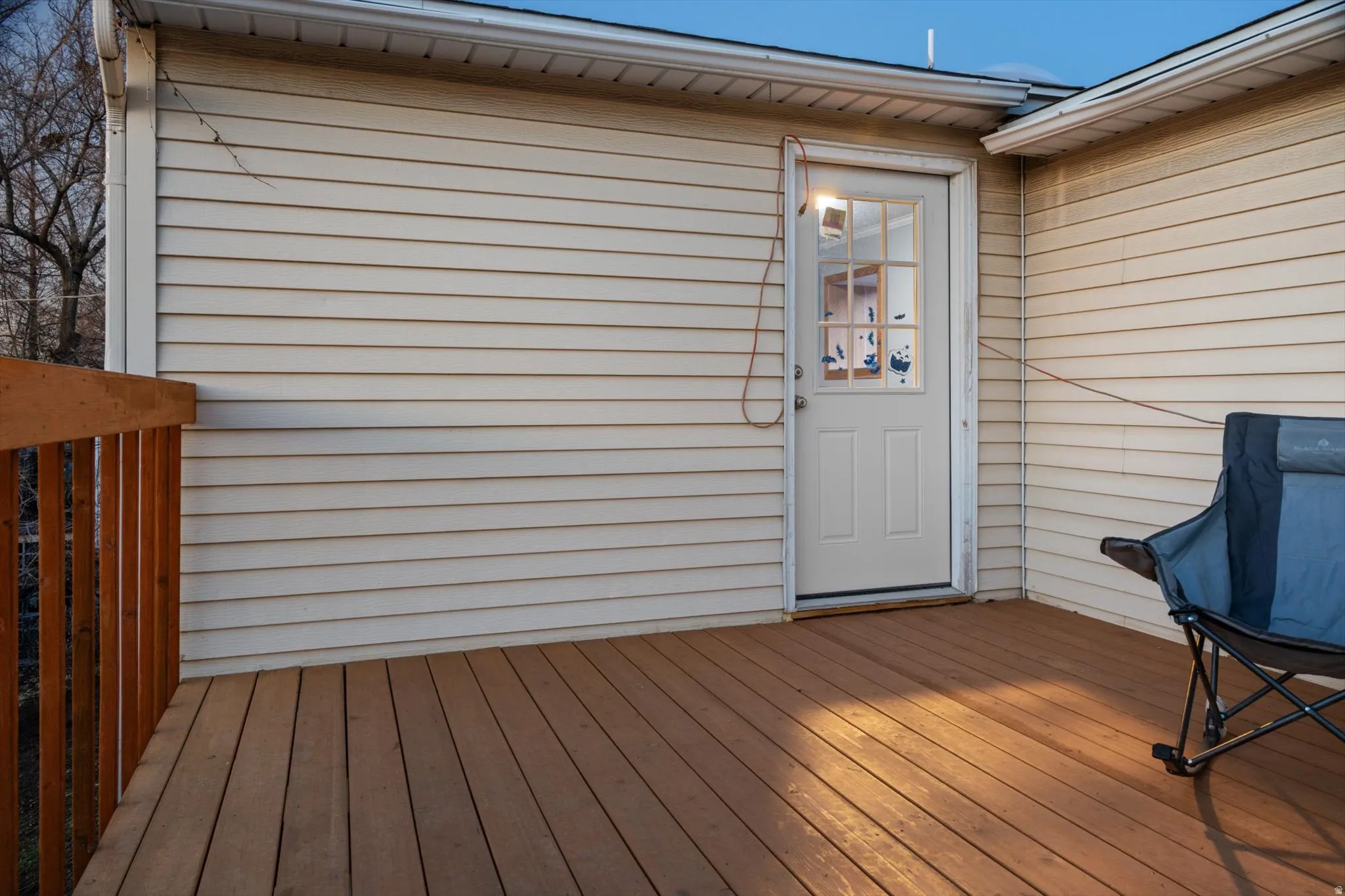 Inviting outdoor deck featuring wood-finish flooring, a coordinating wood railing, and direct access through a paneled door with windowpanes