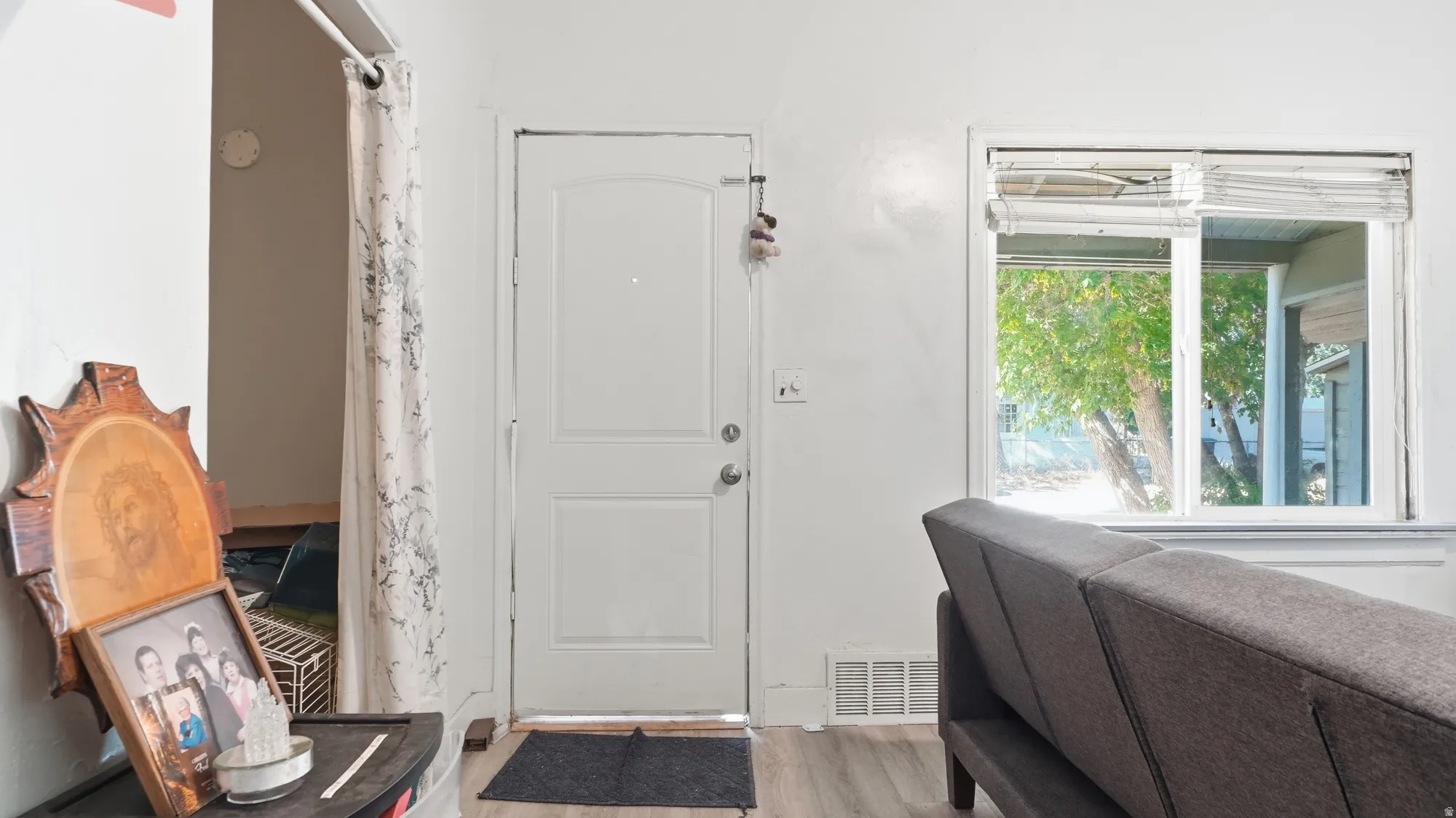 White paneled door, wood-finish flooring, and a large window