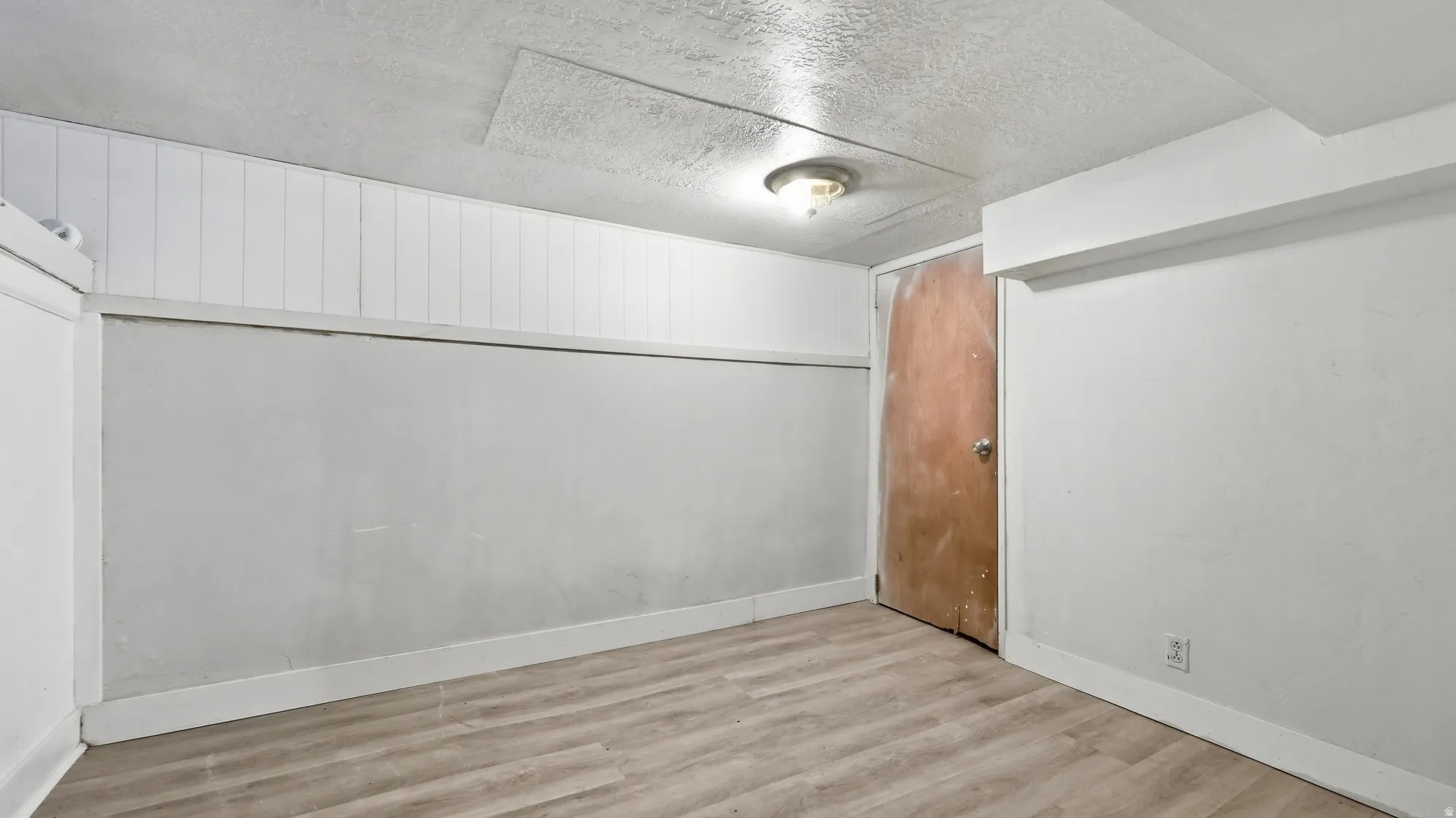 Wood-finish flooring with white wall paneling