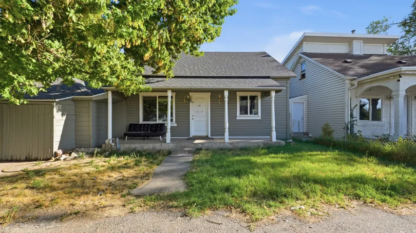 Front porch with white columns, gray siding, and a gabled roof
