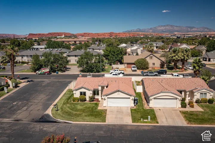 Two single-story residences featuring attached garages, tile roofs, and landscaped front yards