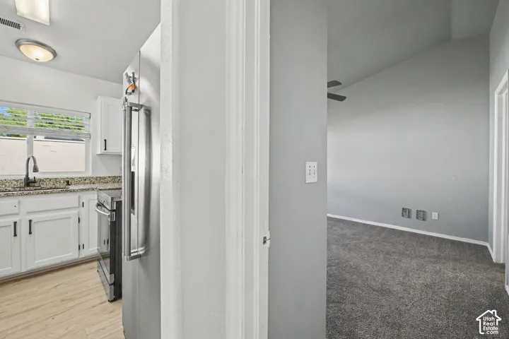 Kitchen featuring white cabinetry, wood-finish flooring, and speckled countertops
