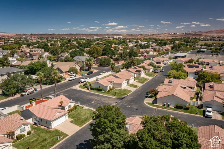 Residential neighborhood featuring mature trees, paved streets, and a mountainous backdrop