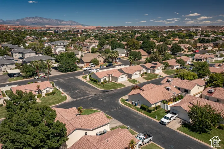 Expansive residential neighborhood featuring single-story homes with tile roofs, mature landscaping, and mountain backdrop
