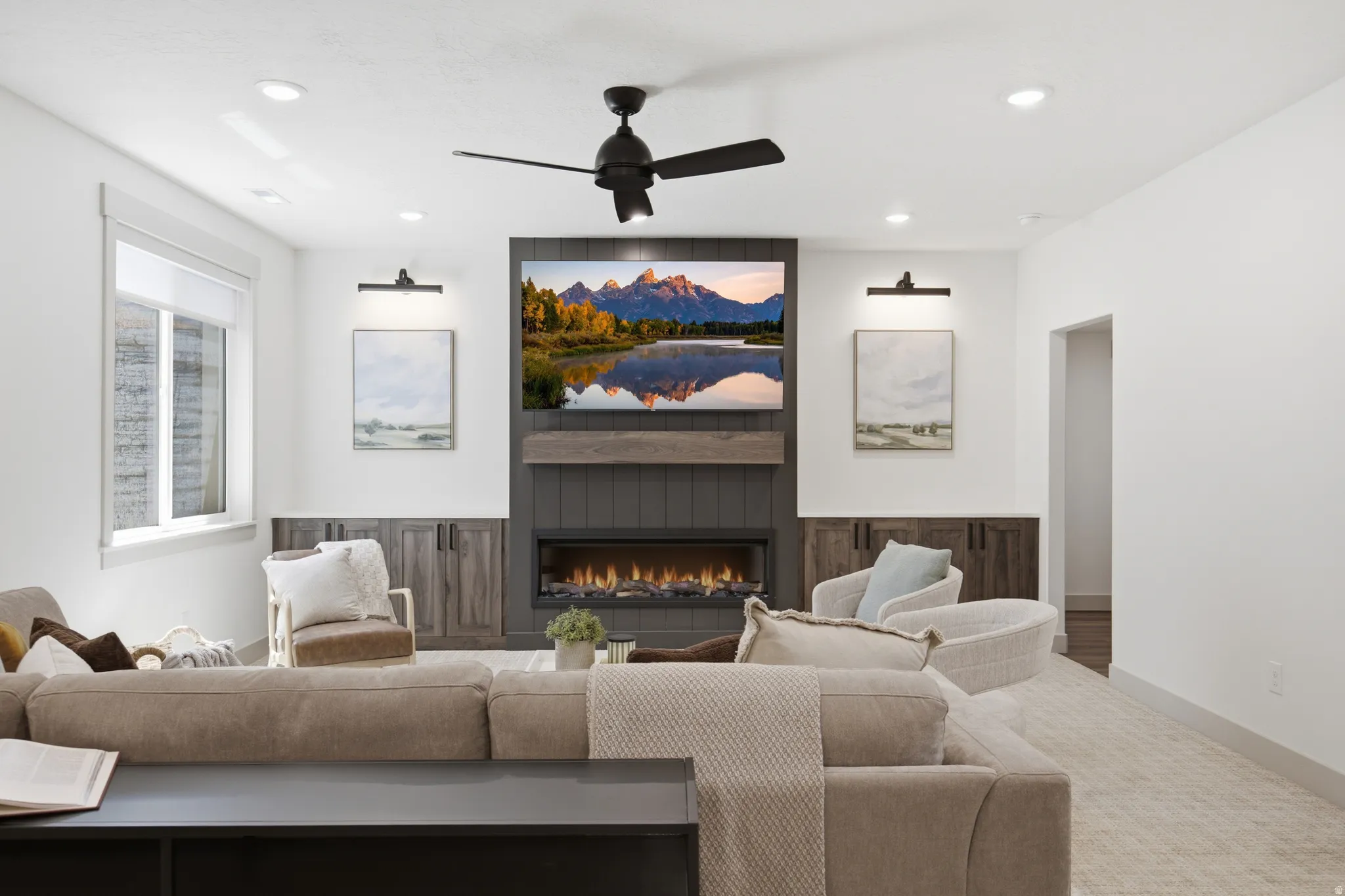 Living area featuring a floor-to-ceiling fireplace with an integrated media center, dark wood-paneled accents, and a wide electric fireplace insert