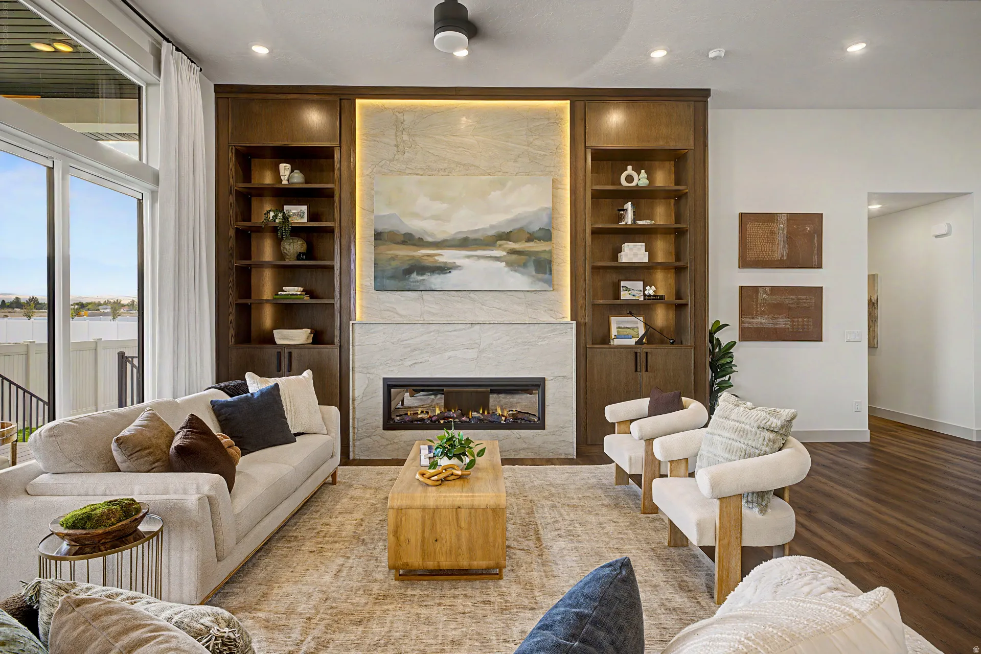Living area featuring a floor-to-ceiling fireplace with stone surround, integrated linear fireplace, and built-in shelving
