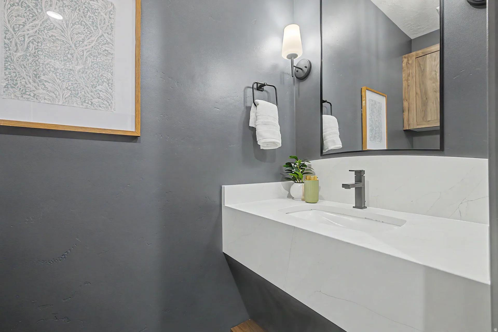 Floating vanity with an integrated rectangular sink, matte black faucet, and white countertop with veining