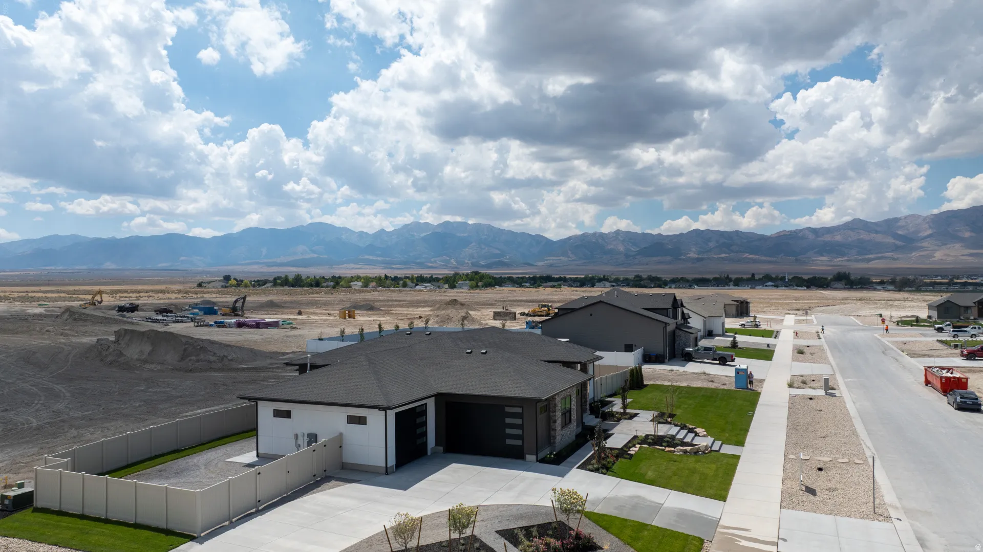 Contemporary single-story residence featuring a dark asphalt shingle roof and a light-colored exterior facade