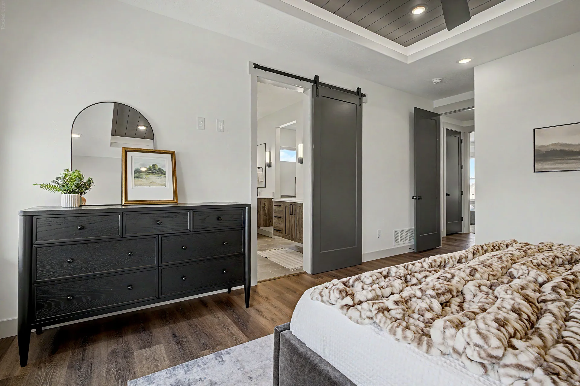 Tray ceiling with wood-finish paneling, recessed lighting, and a ceiling fan