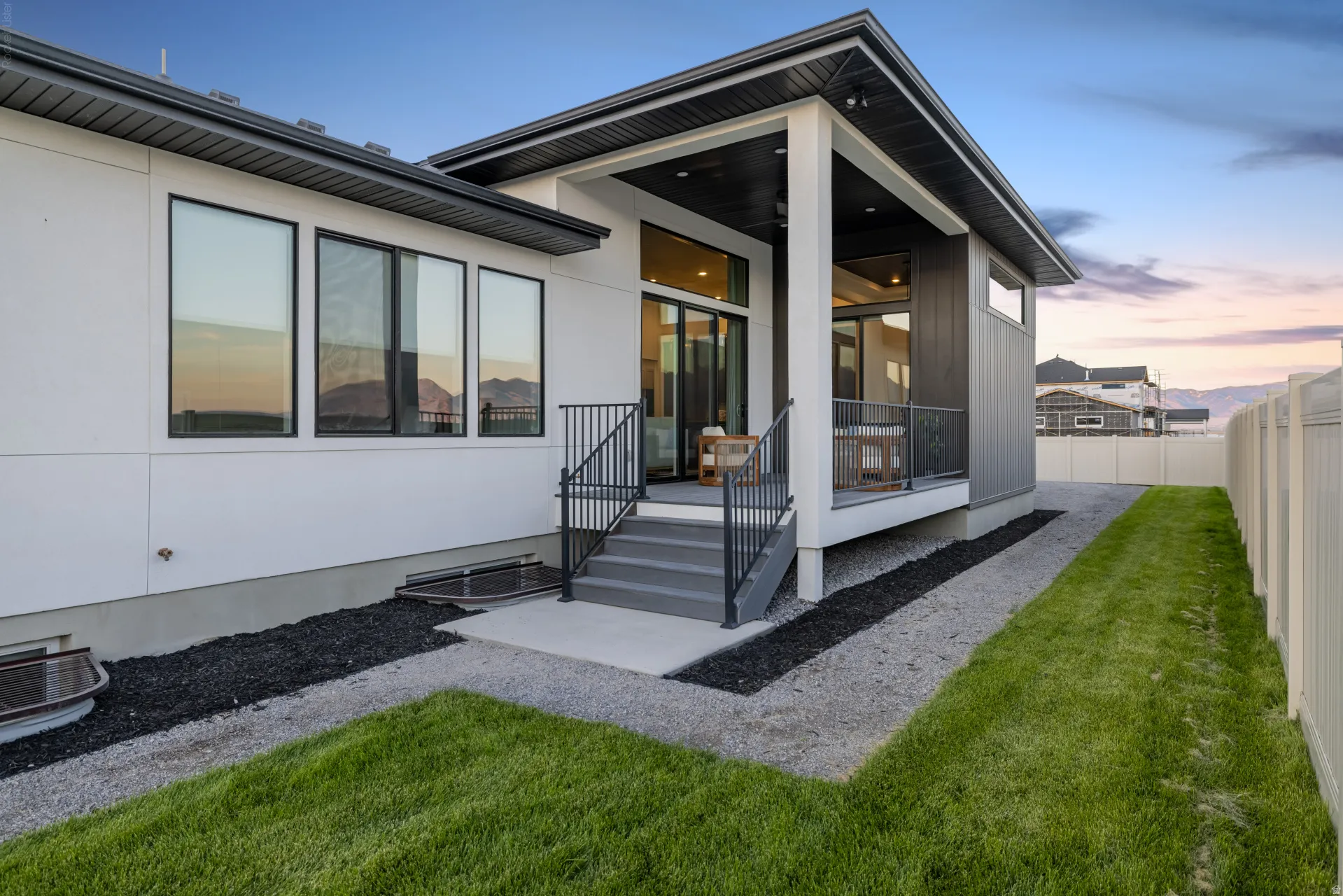Contemporary exterior featuring a covered porch with dark wood-finish ceiling, white pillars, and sliding glass doors