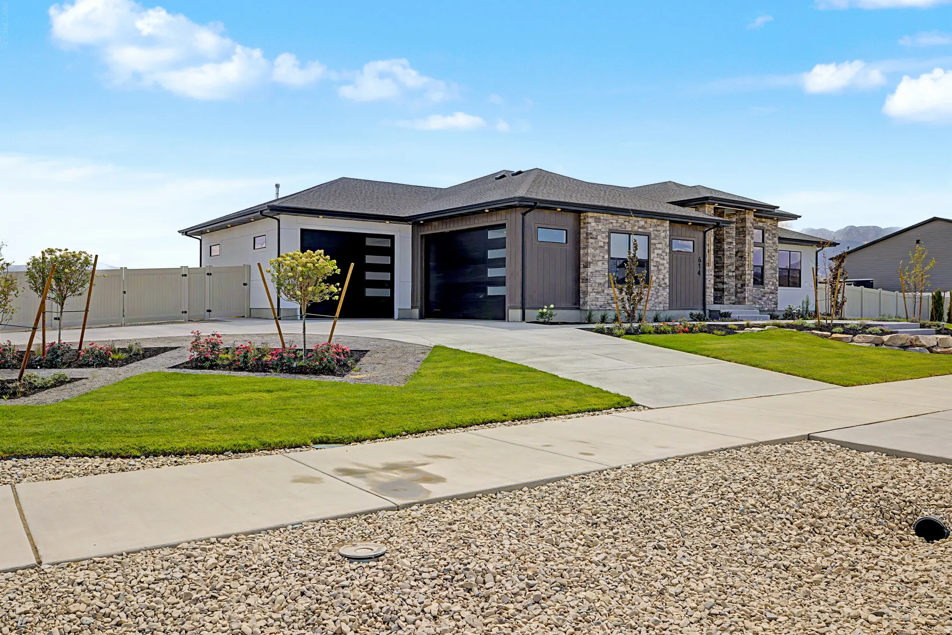 Contemporary residence featuring a multi-material facade with stone accents and vertical siding