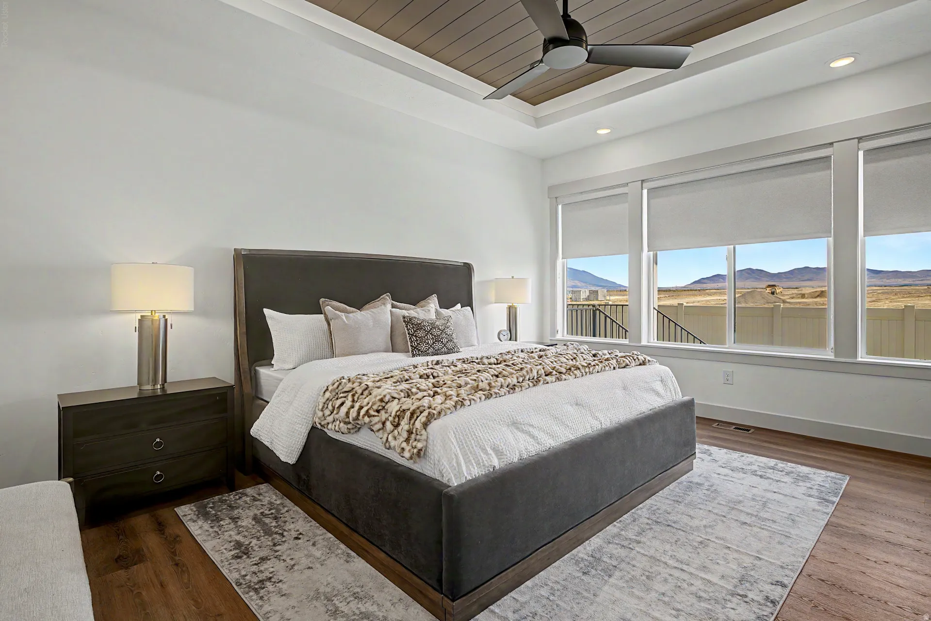 Expansive windows showcasing mountain scenery, complemented by wood-finish flooring