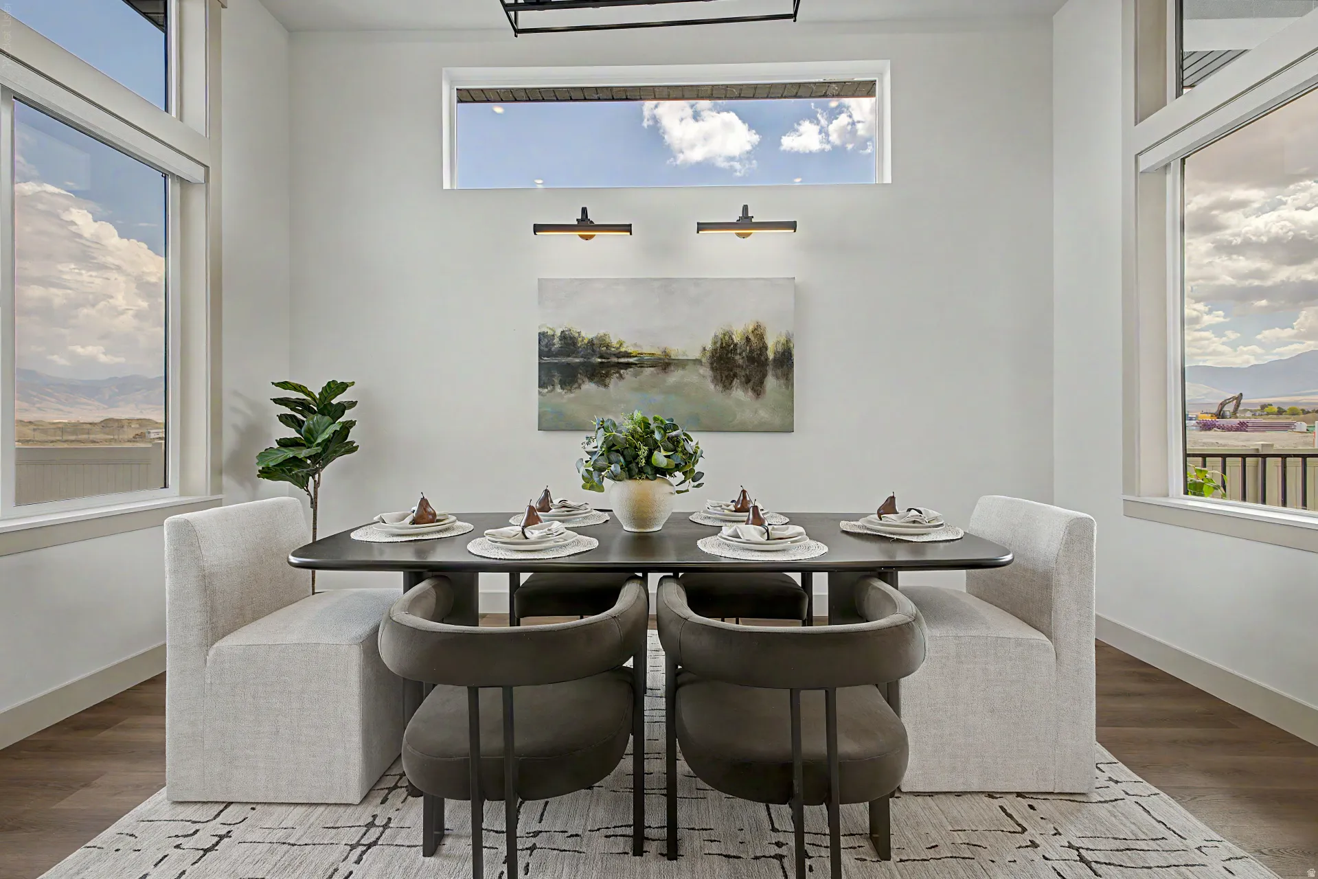 Dining area featuring wood-finish flooring, white baseboards, and a contemporary light fixture