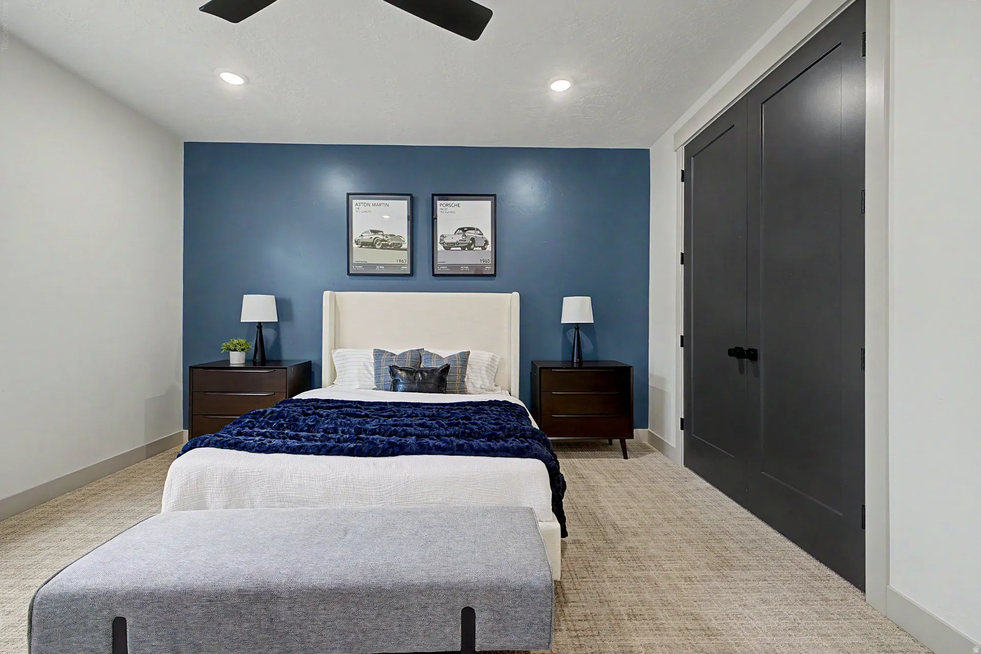 Bedroom featuring a distinctive blue accent wall, recessed lighting, a ceiling fan, and dark panel doors with black hardware