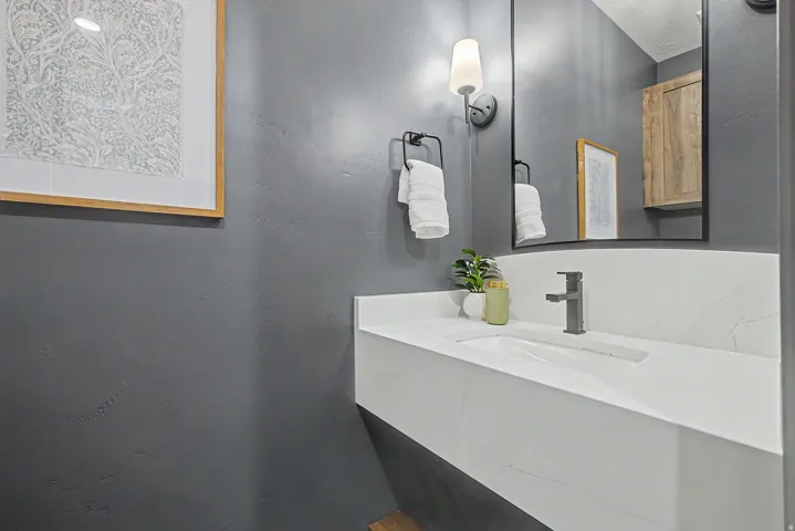 Floating vanity with an integrated rectangular sink, matte black faucet, and white countertop with veining
