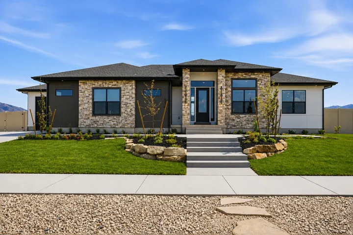 Contemporary ranch-style residence featuring a stone and siding facade