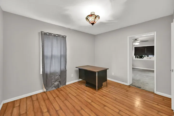 Wood-finish flooring, light gray wall paint, and an ornate ceiling light fixture