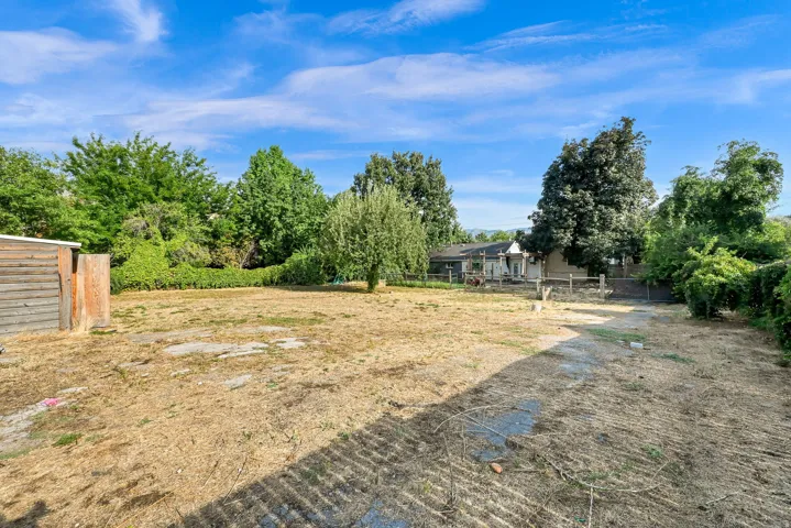 Expansive lot featuring mature trees and a wood-sided outbuilding