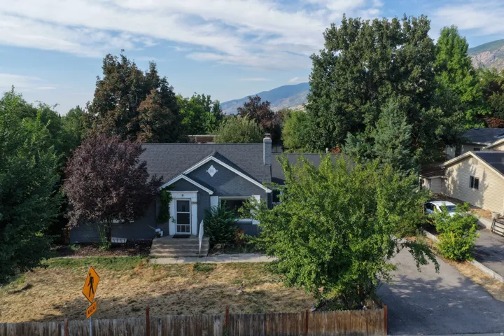 Single-story residence featuring a dark gray exterior, white trim details, and a sloped roof