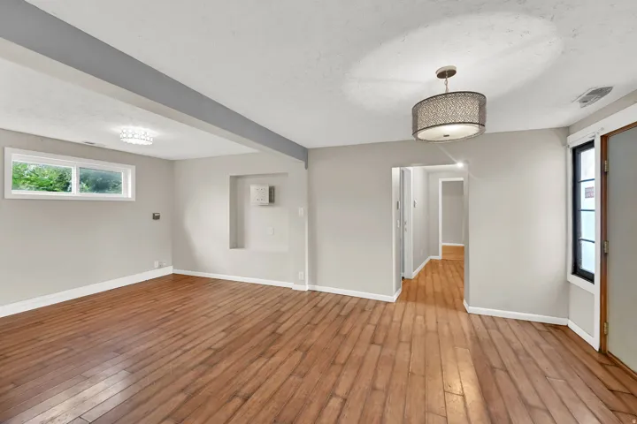 Wood-finish flooring, recessed wall niche, and modern ceiling light fixtures