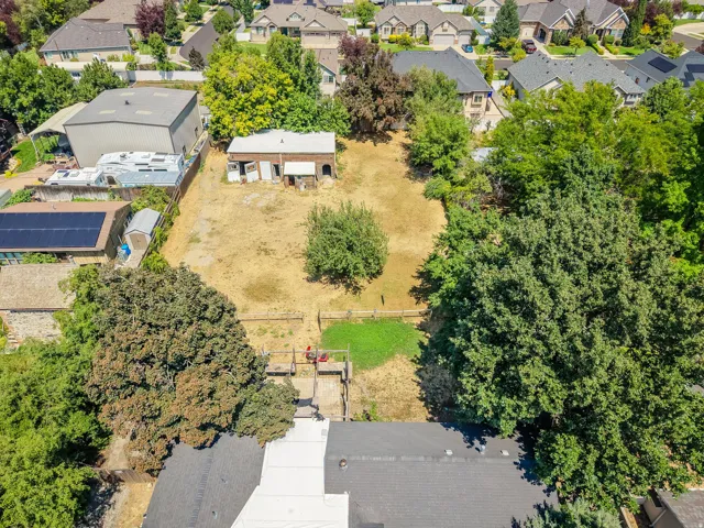 Expansive lot featuring mature trees, a detached outbuilding, and varied terrain