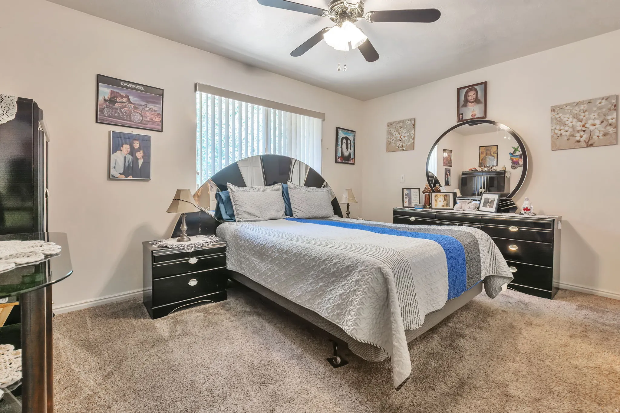 Carpeted room featuring a ceiling fan with integrated lighting, a window with vertical blinds, and neutral wall tones