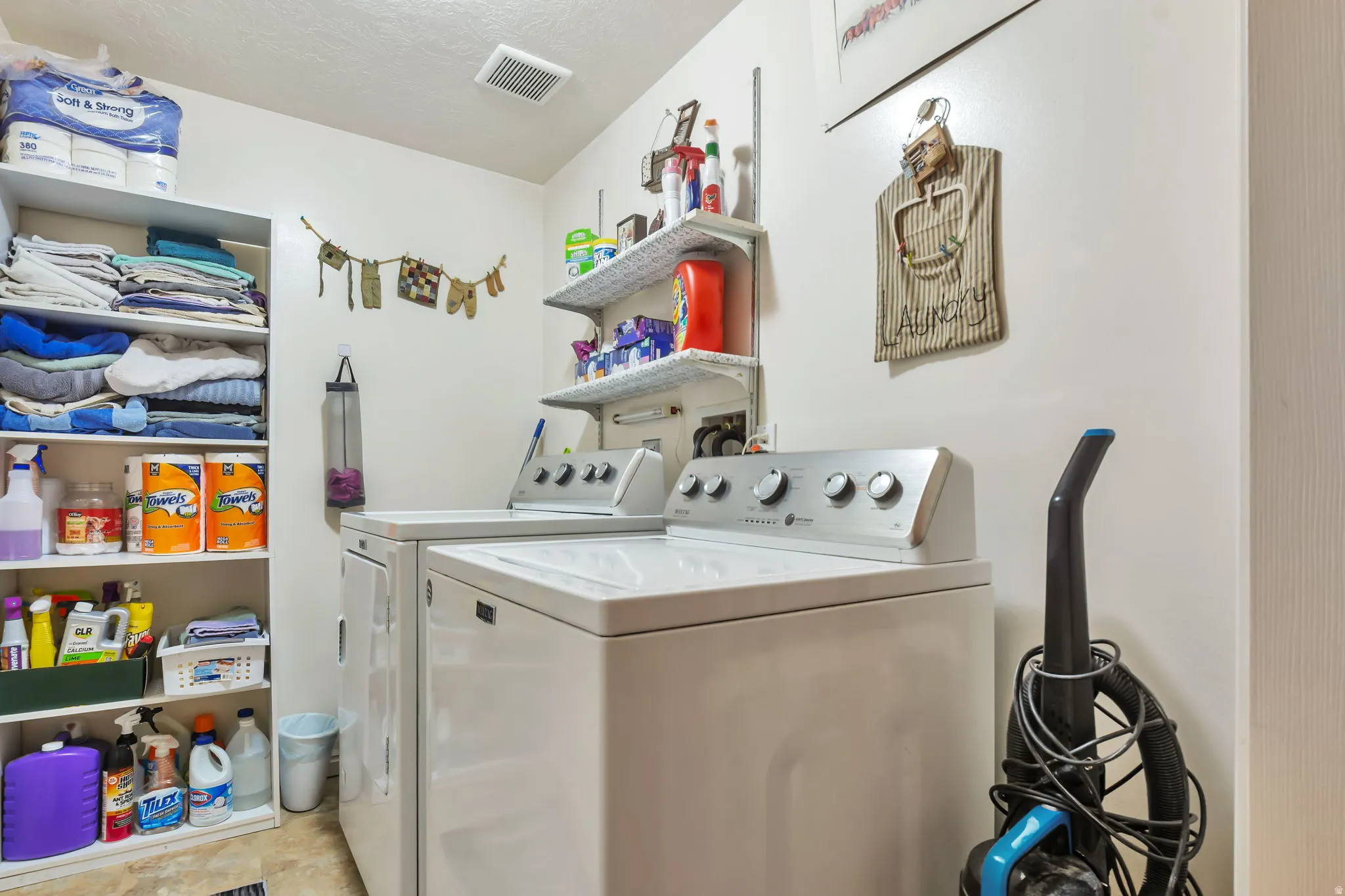 Dedicated laundry space featuring a white top-load washing machine and a white front-load dryer