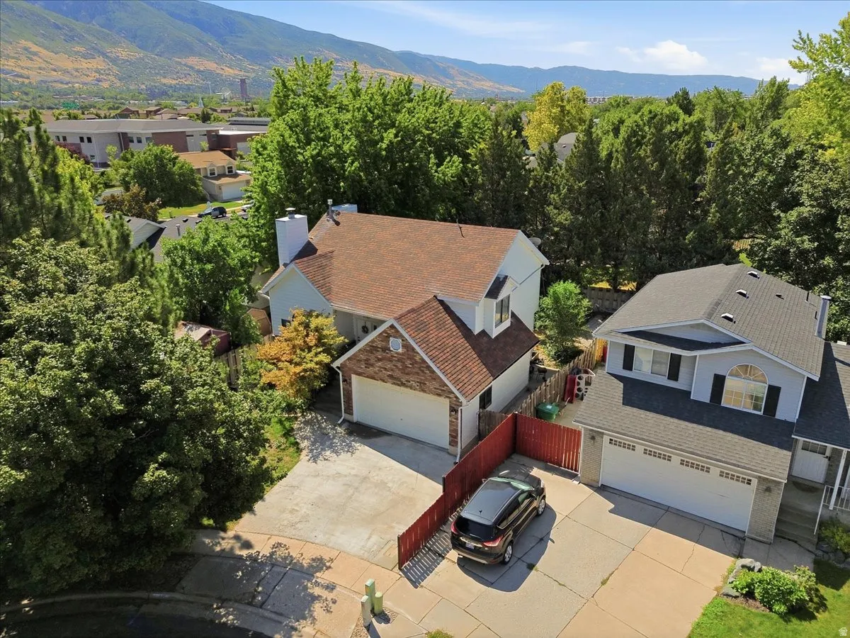 Two-story residence with an attached two-car garage, partial brick facade, and a private fenced yard