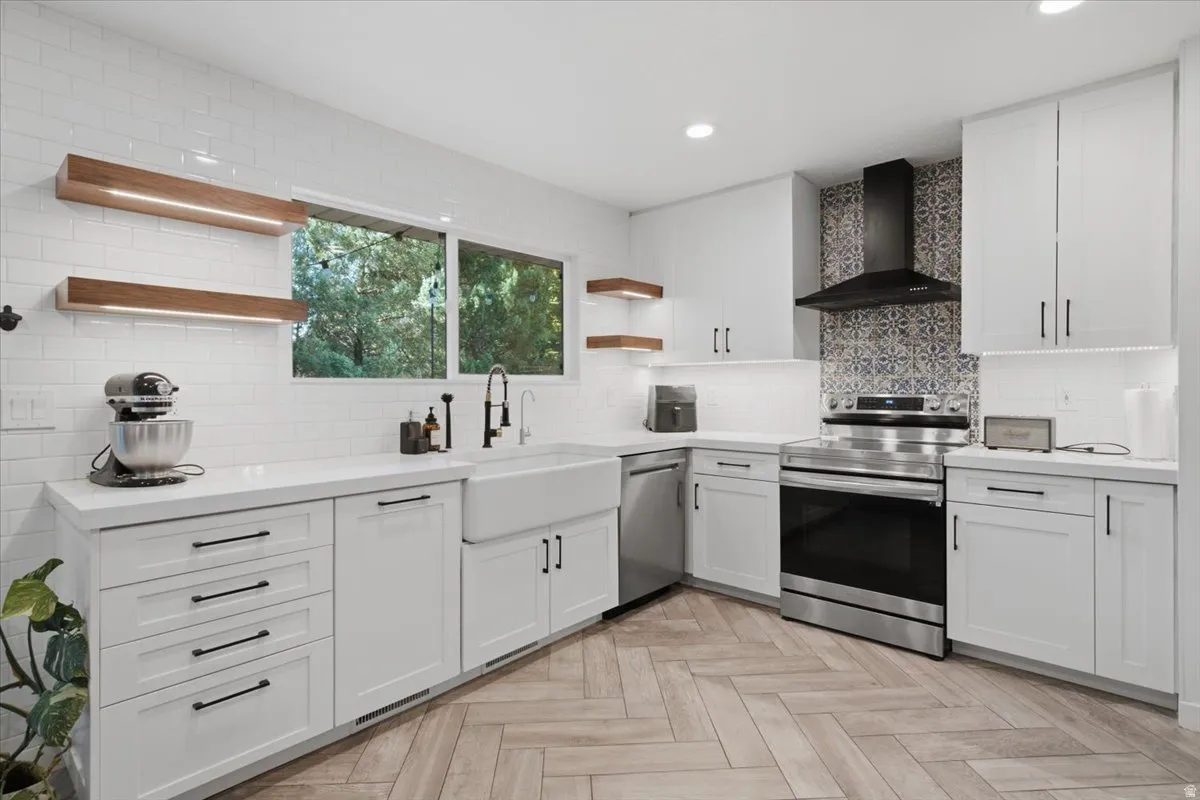 Modern kitchen featuring white shaker cabinetry, quartz countertops, and herringbone wood-finish flooring