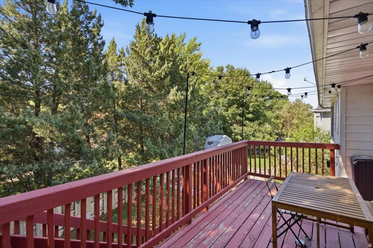 Wooden deck with a deep red railing and natural wood-finish flooring