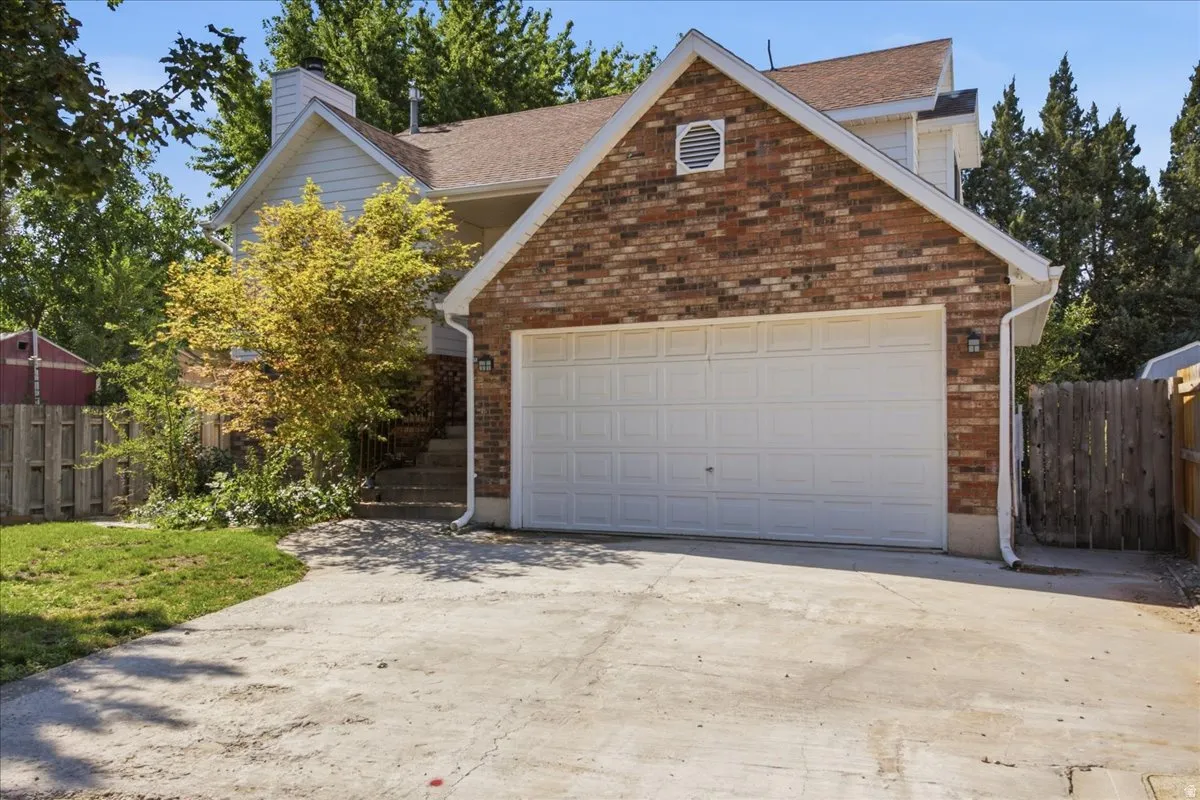 Brick-front facade featuring an attached two-car garage with a panel door