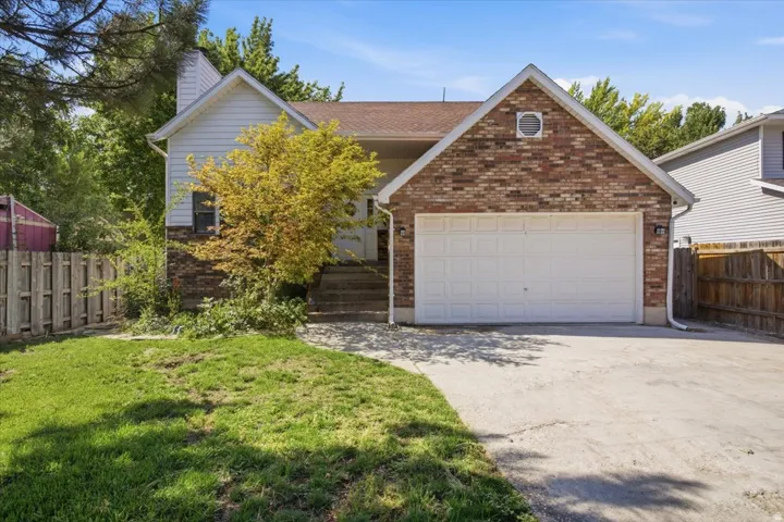 Brick and siding exterior featuring an integrated two-car garage with a white panel door