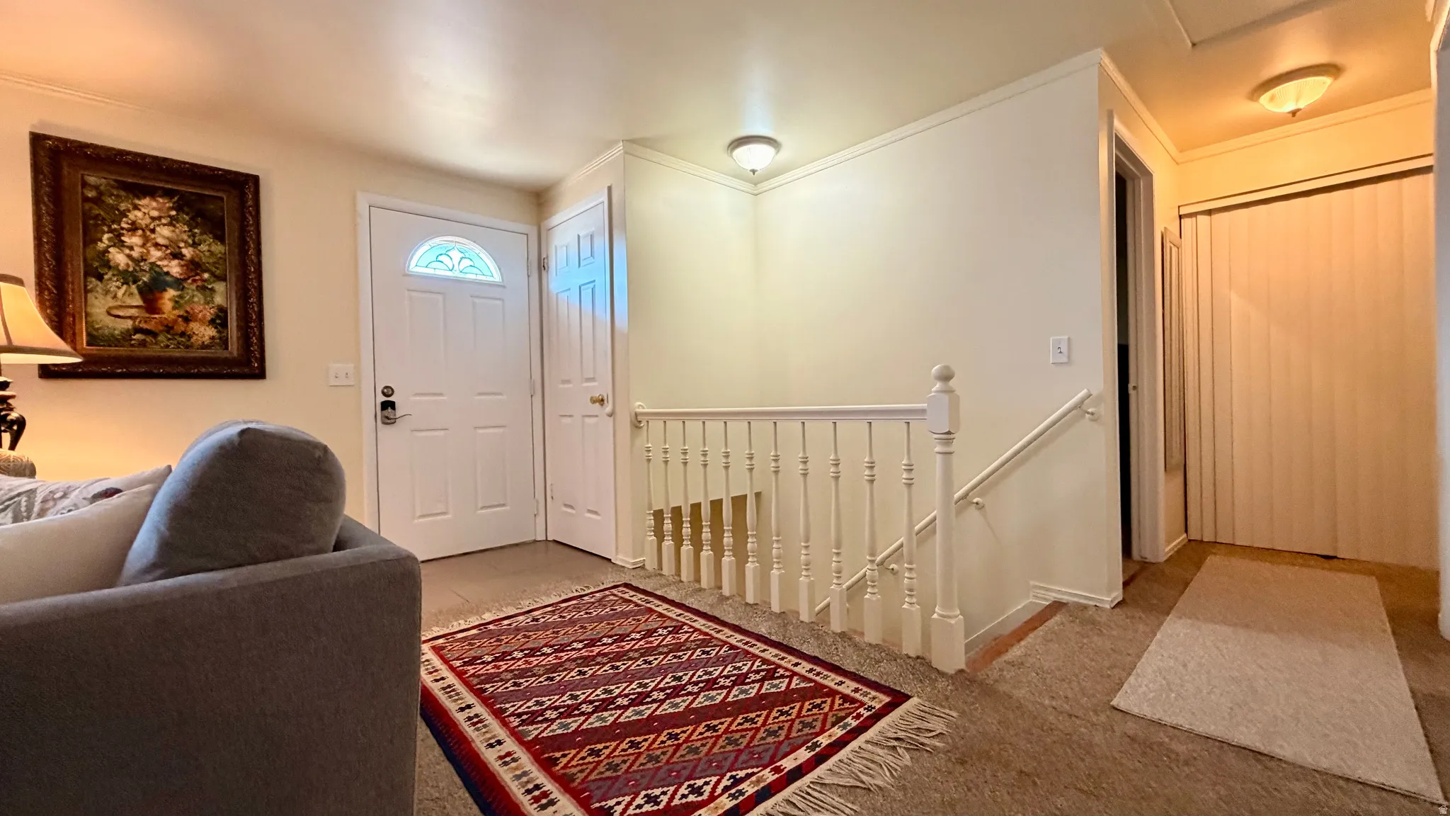 Entryway featuring a white paneled door with an arched glass insert, light-colored wall paint, and a carpeted floor