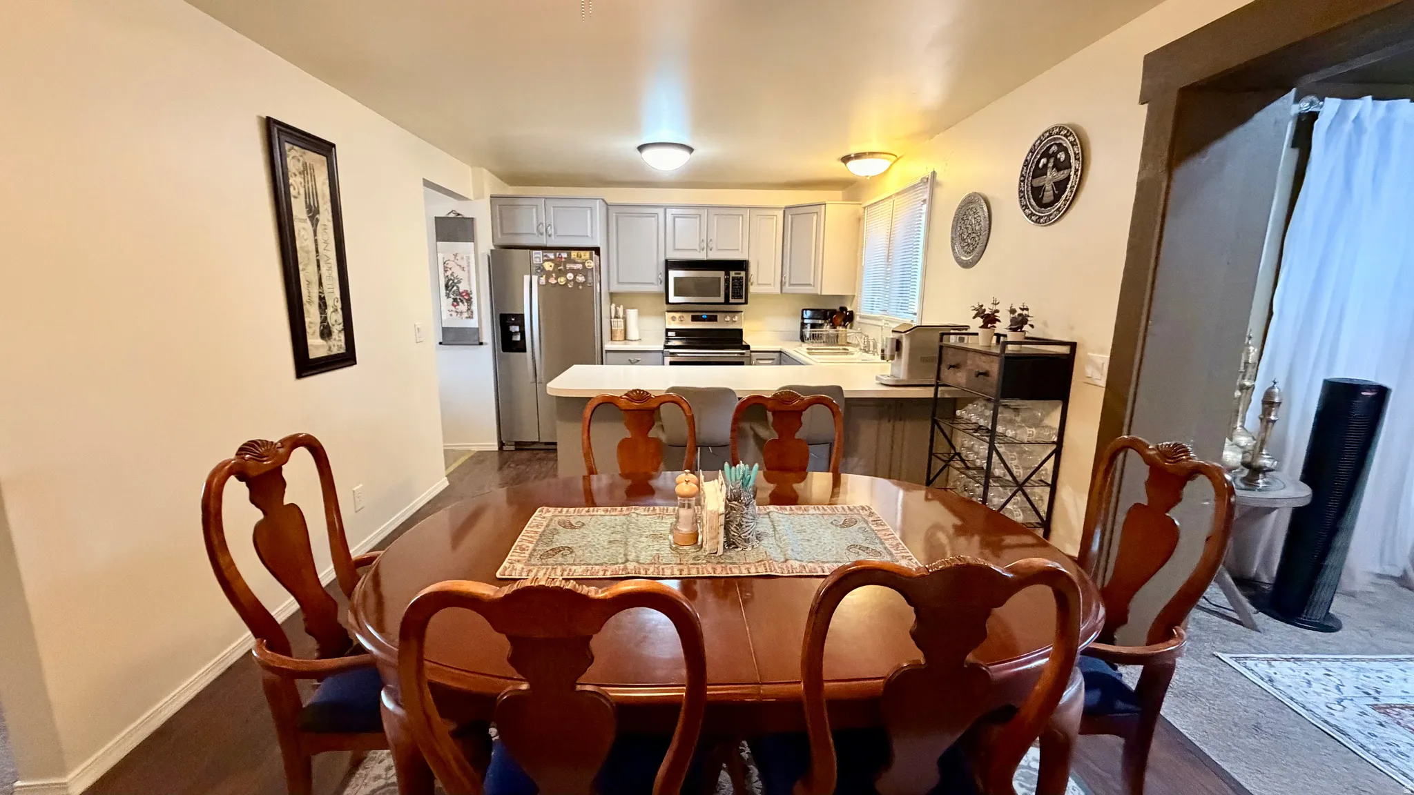 Dining area featuring wood-finish flooring, a neutral wall color, and an open concept layout with sightlines into the kitchen