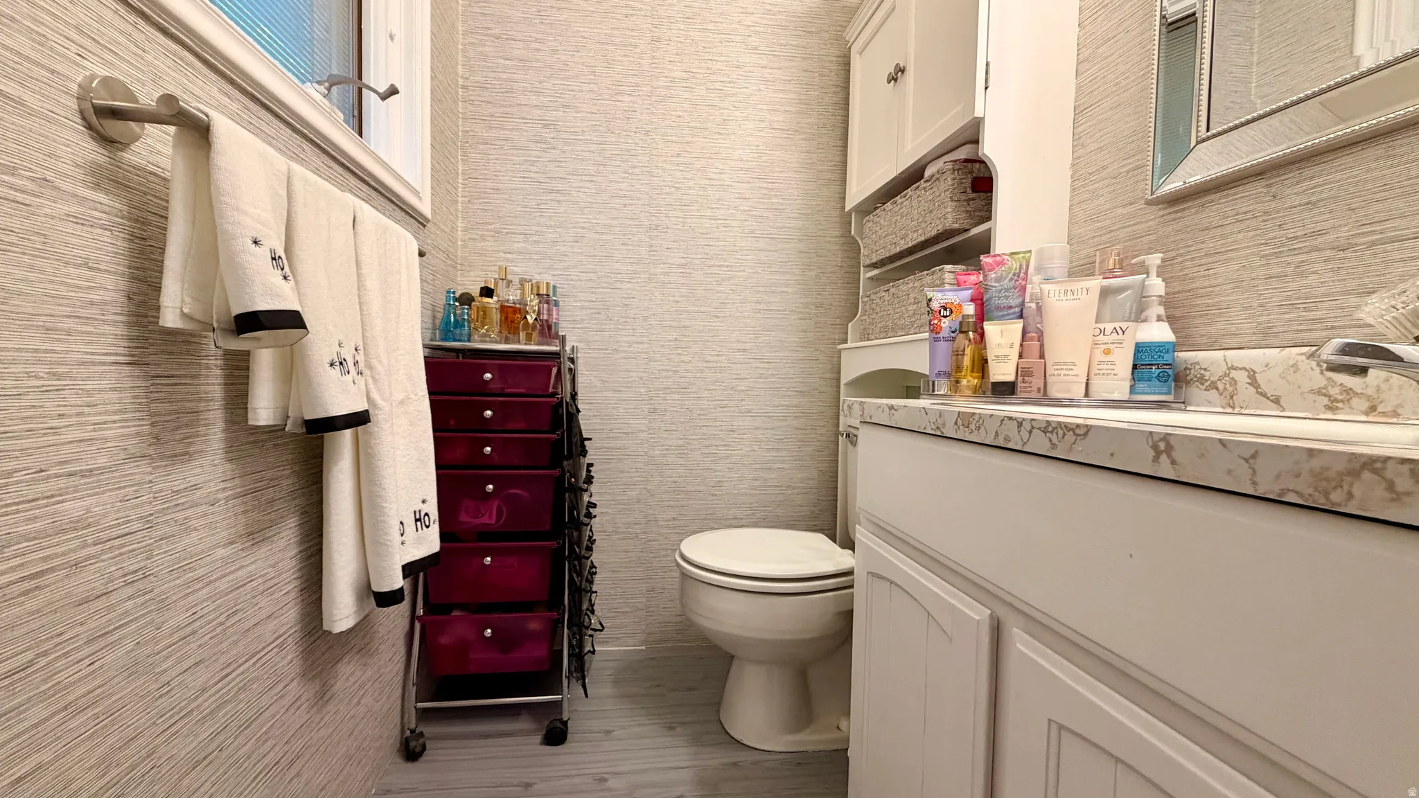 Bathroom featuring light-toned textured wall covering