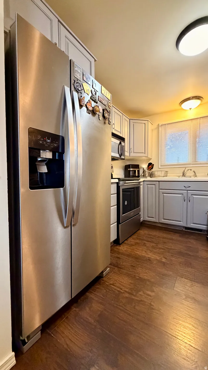 Kitchen featuring stainless steel appliances, wood-finish flooring, light grey cabinetry, and recessed lighting