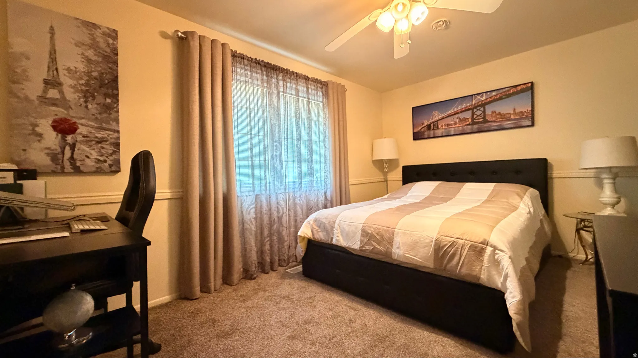 Bedroom featuring a window with sheer and solid drapes, a ceiling fan with integrated lighting, and carpet flooring