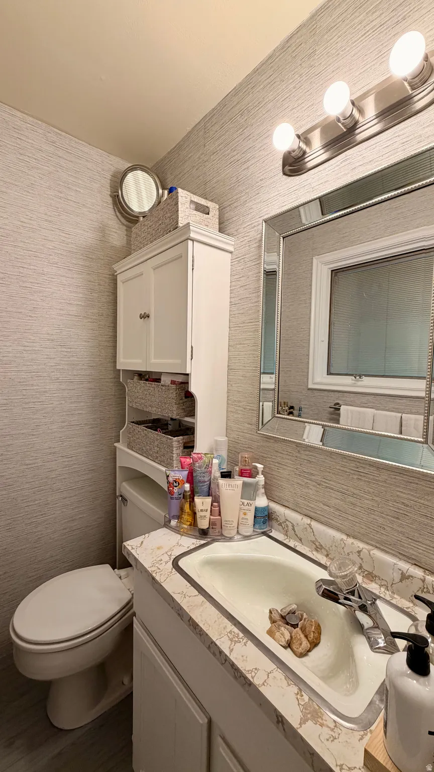 Bathroom featuring a built-in white vanity with an integrated sink and patterned countertop
