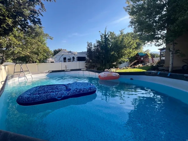 Above-ground heated swimming pool featuring a ladder for access