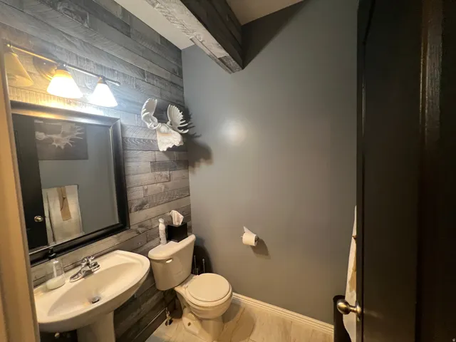 Pedestal sink with chrome faucet, framed mirror, and dual-light fixture