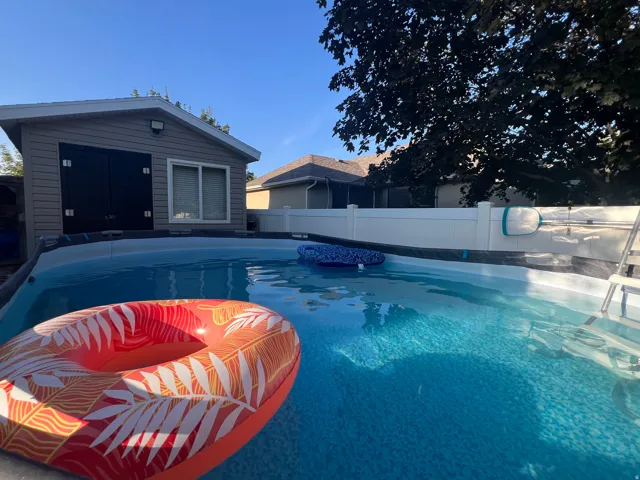 Above-ground heated swimming pool featuring an integrated ladder