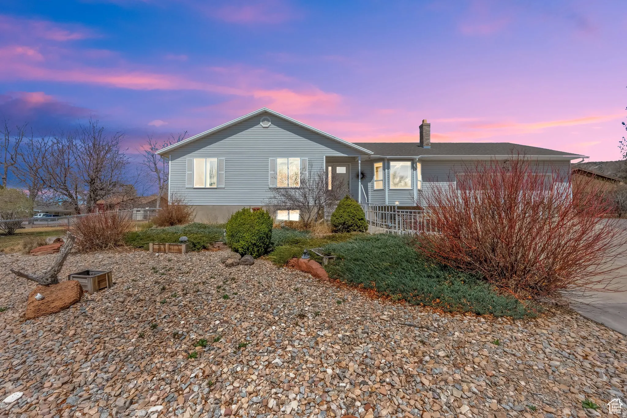 Charming single-story residence with light-colored vinyl siding and a welcoming front elevation