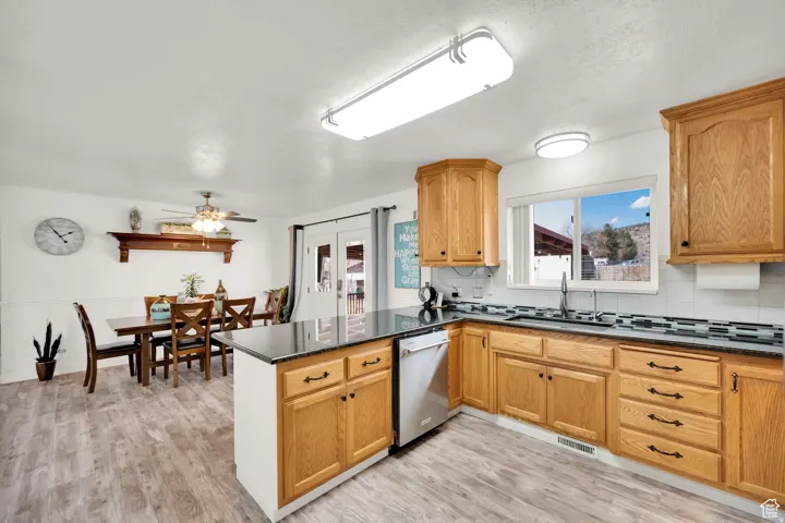 Kitchen featuring wood-finish cabinetry, dark countertops, and stainless steel appliances