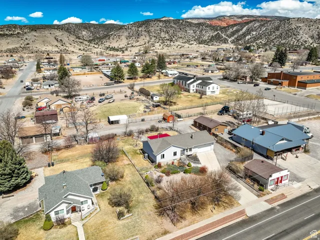 Expansive aerial perspective showcasing a residential property with a light-colored exterior and attached garage