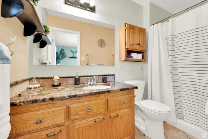 Bathroom vanity with a brown marbled countertop and an integrated sink, complemented by a wood-finish cabinet with decorative hardware