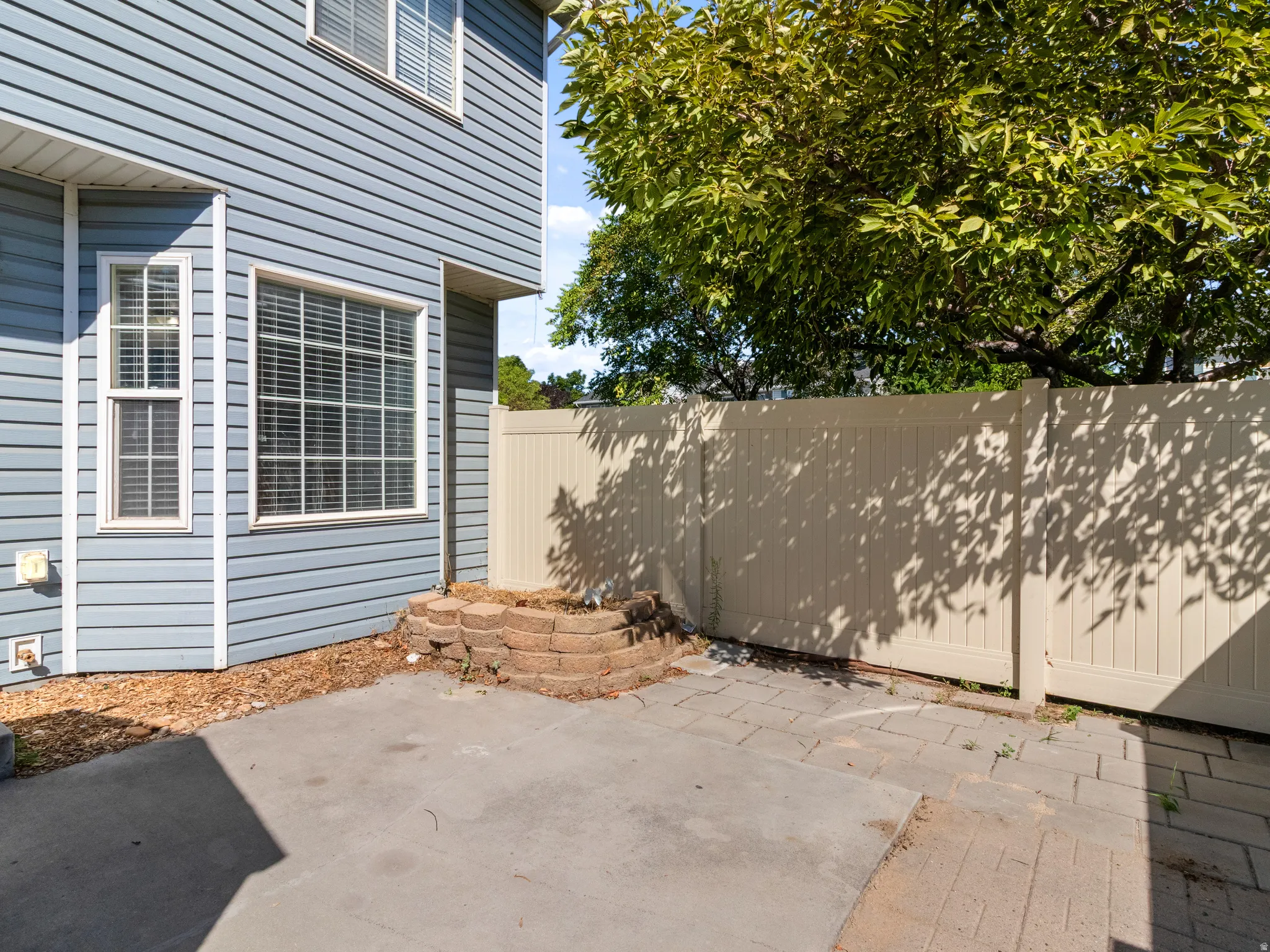 Private outdoor patio featuring a concrete slab and paver sections