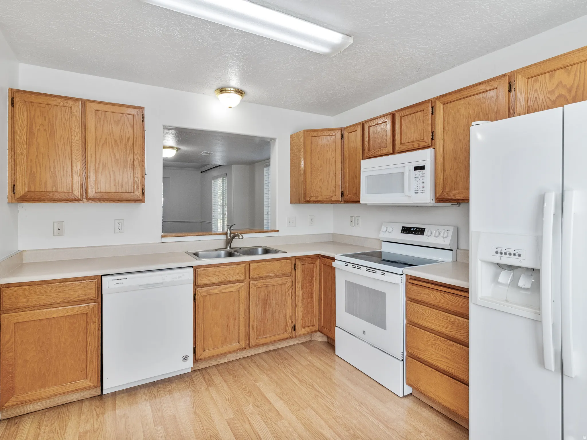 Kitchen featuring wood-finish flooring, light wood cabinetry, and laminate countertops
