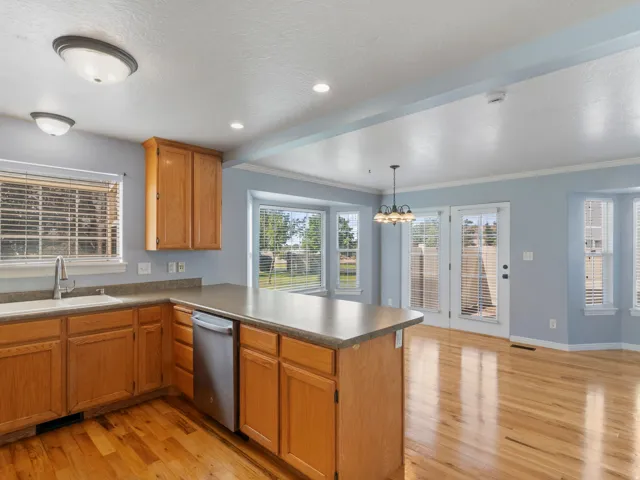 Kitchen featuring wood-finish cabinetry, stainless steel dishwasher, and a built-in sink